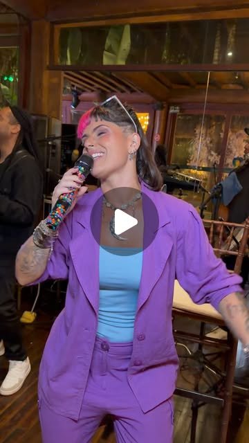 Rafa Guttierrez cantando em traje roxo, ambiente intimista