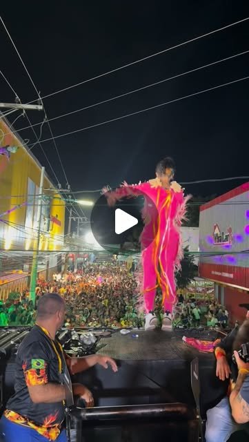 Rafa Guttierrez cantando em cima de trio elétrico no Carnaval, fantasia rosa, multidão